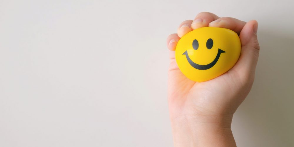 Hand squeeze yellow stress ball to relax.